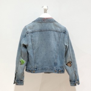 jean jacket with artist-designed patches featuring a butterly, a caterpillar, and a leaf