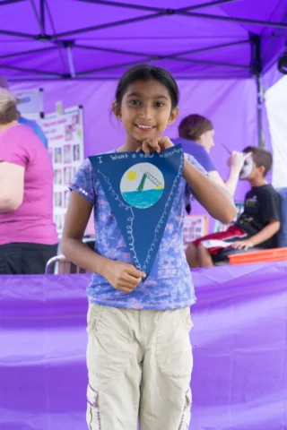 DSC08852 A girl holds up a flag that says "I want a new waterpark"