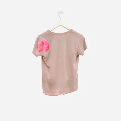 a hot pink rose appliqued ontop of a dirty, faded pink t-shirt in and example of visible mending