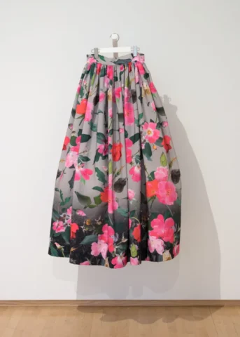 a voluminous skirt made of vibrant pink roses fabric with a dark engineered border