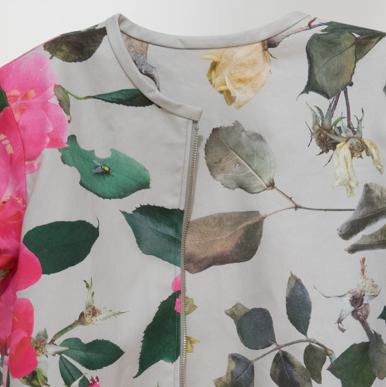 A double-sided, reversible jacket shows a photographic repeat pattern of roses in both summer and winter
